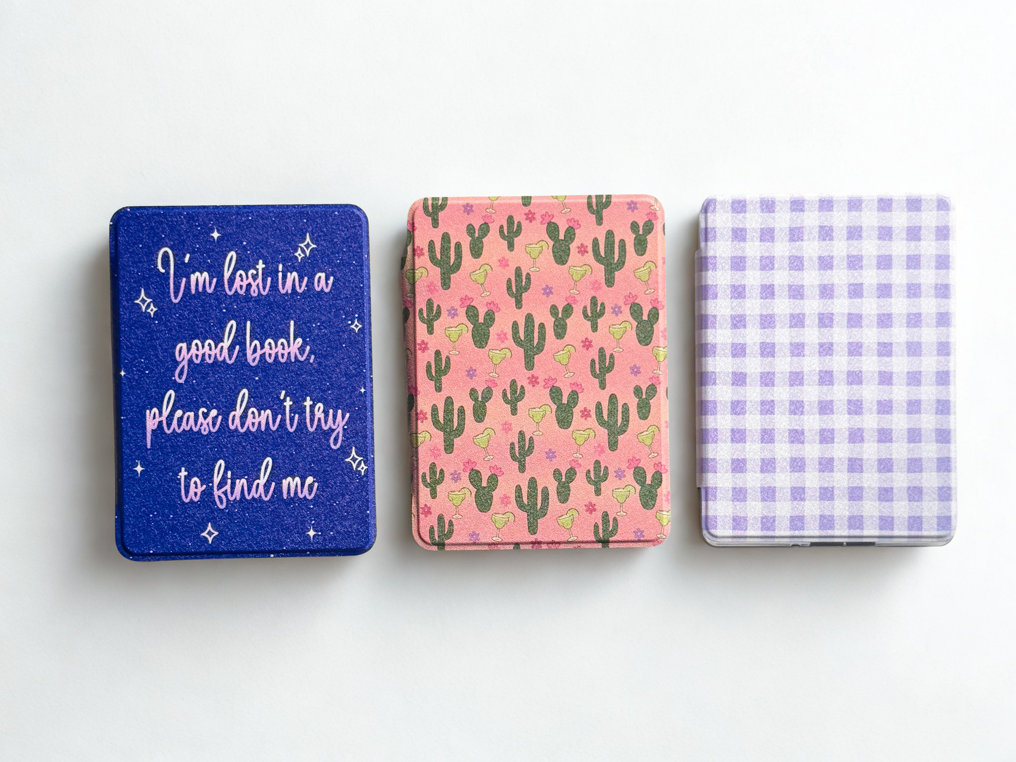 Three custom kindle cases with different designs on them